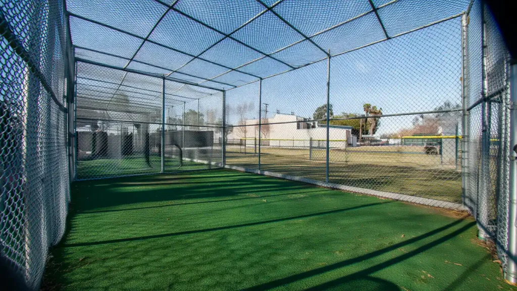 Professional batting cage installation with artificial turf and chain-link netting for Stockton CA sports facility, built by Stockton Swift Fix for durability and safety.